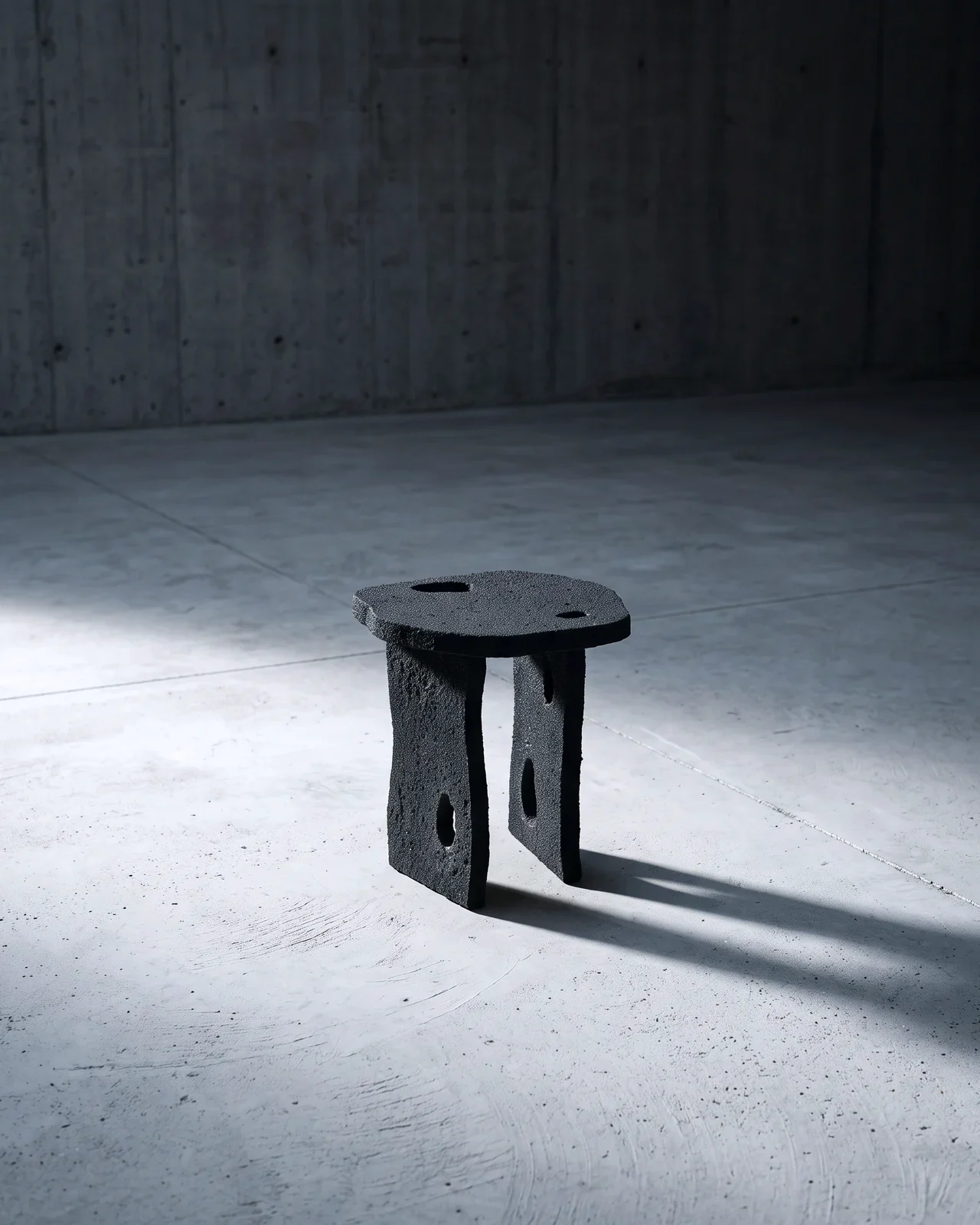 Aetna Stool alone in a concrete room, in a raking light, by Paul Hardy