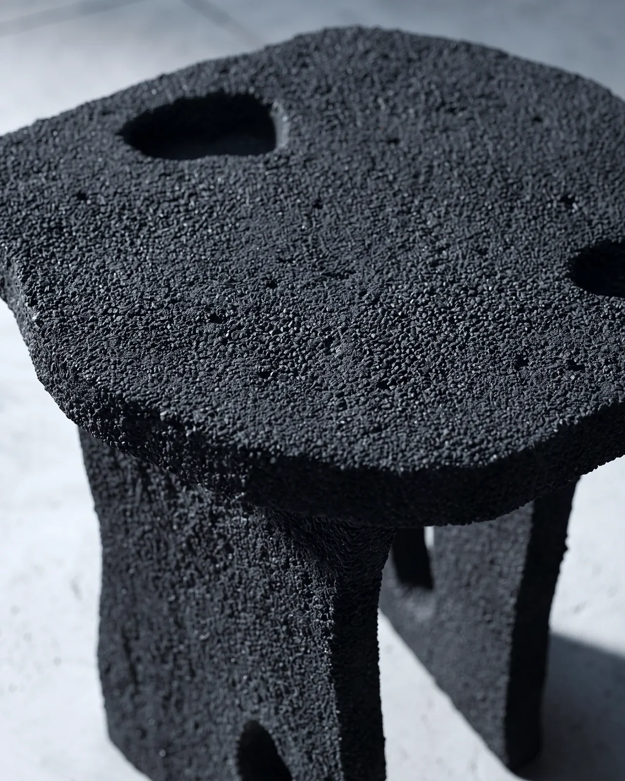 Seat of the Aetna Stool, black sand grain and carved hollows, by Paul Hardy