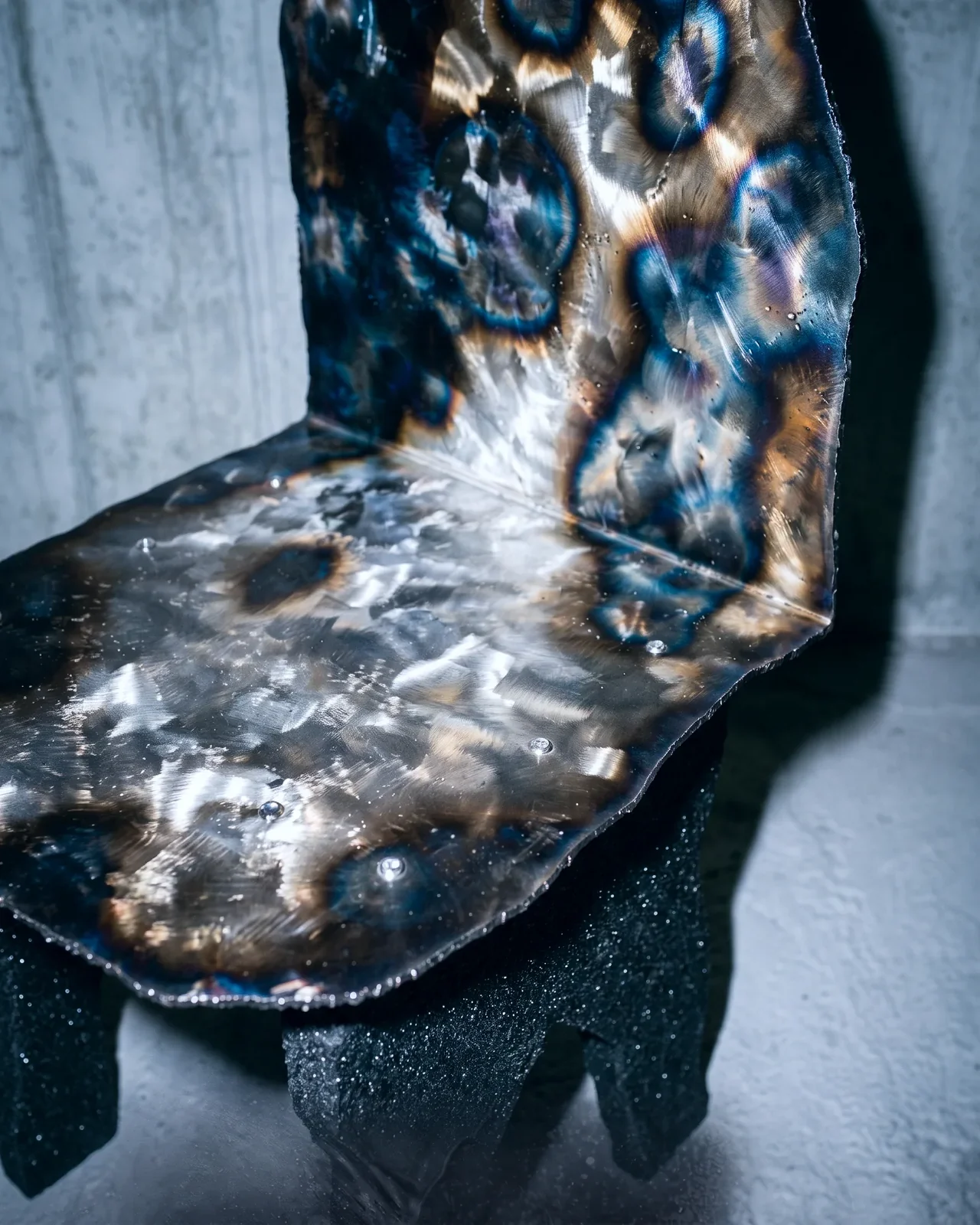 Heat-tinted steel seat of the Ustio Chair, by Paul Hardy