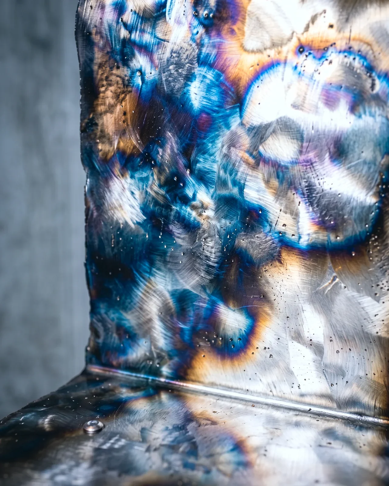 Blue, violet and amber heat tint on the backrest, Ustio Chair, by Paul Hardy