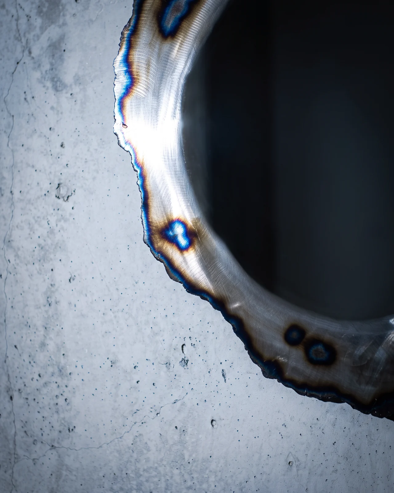 Polished steel frame around the dark mirror, Ustio Mirror, by Paul Hardy