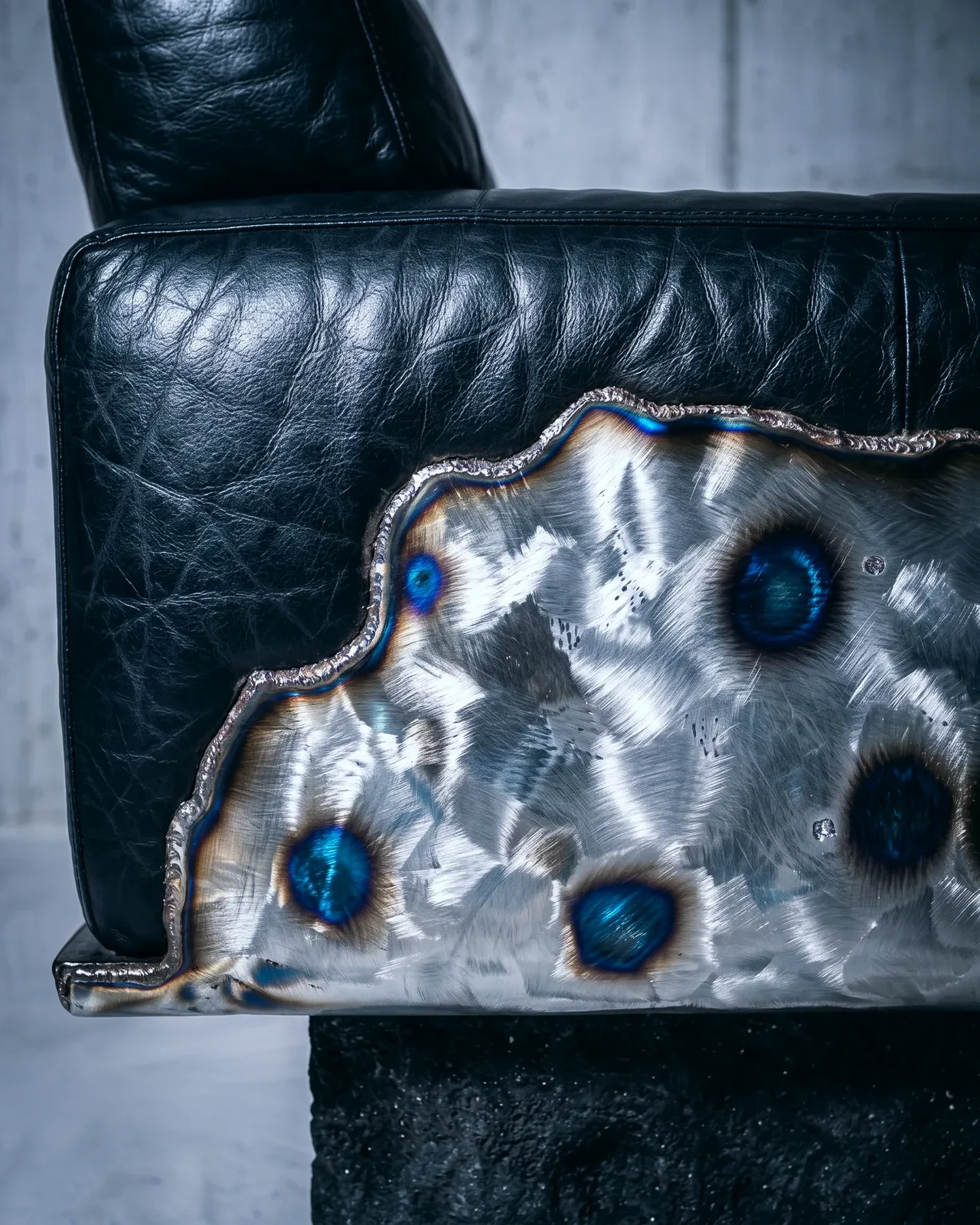 Heat-tinted steel panel set into the leather arm, Ustio Sofa, by Paul Hardy